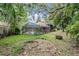 A serene backyard featuring a pool in a screened enclosure with mature trees at 3013 Crest Dr, Clearwater, FL 33759