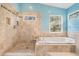 Bright bathroom featuring walk in shower, soaking tub and travertine tile at 3013 Crest Dr, Clearwater, FL 33759