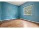 Bedroom with wood floors, blue walls, and a large window at 3013 Crest Dr, Clearwater, FL 33759