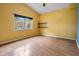 Sunlit bedroom featuring wood floors and shelves, with a large window view at 3013 Crest Dr, Clearwater, FL 33759