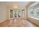 Bright dining room area with tile flooring, bay windows, and French doors leading to the backyard at 3013 Crest Dr, Clearwater, FL 33759