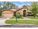 Attractive two-story home with well-kept lawn, decorative landscaping, attached garage, and inviting front entryway at 3013 Crest Dr, Clearwater, FL 33759