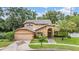 Elegant two-story home with a two-car garage, manicured lawn, and lush landscaping at 3013 Crest Dr, Clearwater, FL 33759