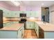 Large kitchen featuring an island, tiled floor, light cabinets and stainless steel appliances at 3013 Crest Dr, Clearwater, FL 33759