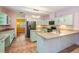 Open kitchen with tiled floor, light-colored cabinets and stainless steel appliances at 3013 Crest Dr, Clearwater, FL 33759