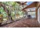 Covered patio with brick flooring, offering a view of a lush backyard with a pool at 3013 Crest Dr, Clearwater, FL 33759