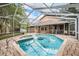 Wide backyard featuring a screened-in pool and hot tub, perfect for relaxation at 3013 Crest Dr, Clearwater, FL 33759