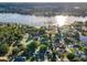 Breathtaking aerial view of a waterfront community boasting lake access, lush greenery, and a tennis court at 3047 Lake Padgett Dr, Land O Lakes, FL 34639