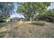 Scenic backyard view with a screened-in porch, lush lawn and established landscaping; great for entertaining at 3047 Lake Padgett Dr, Land O Lakes, FL 34639
