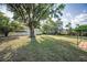 Expansive backyard featuring a large shade tree with a spacious lawn, great for outdoor activities at 3047 Lake Padgett Dr, Land O Lakes, FL 34639