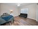 Minimalist bedroom with wood floors, a twin bed, and a futon offers a simple and functional space at 3047 Lake Padgett Dr, Land O Lakes, FL 34639