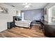 Cozy bedroom with a blue accent wall, a desk, and wood-look floors at 3047 Lake Padgett Dr, Land O Lakes, FL 34639
