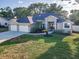 Inviting single-story home showcasing a spacious three-car garage and beautifully landscaped front yard at 3047 Lake Padgett Dr, Land O Lakes, FL 34639