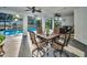 Covered patio area, featuring a dining set with an outdoor pool view at 3047 Lake Padgett Dr, Land O Lakes, FL 34639