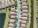 Scenic overhead view of a community featuring tile-roofed homes nestled along canals, complemented by lush landscaping and mature trees at 310 Cedar Falls Dr, Apollo Beach, FL 33572