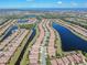 Overhead view of tile-roofed homes in a lakeside community with lush landscaping and a serene atmosphere at 310 Cedar Falls Dr, Apollo Beach, FL 33572