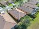 Overhead image of homes with tile roofs surrounded by green grass and trees within a well-maintained community at 310 Cedar Falls Dr, Apollo Beach, FL 33572