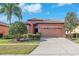 Charming single-story home featuring a well-manicured lawn, mature landscaping, and a two-car garage at 310 Cedar Falls Dr, Apollo Beach, FL 33572