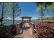 A wood bridge leads to a covered gazebo with a tile roof overlooking the lake and surrounding community at 310 Cedar Falls Dr, Apollo Beach, FL 33572