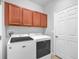 Convenient laundry room with modern washer and dryer units and cabinetry for storage at 310 Cedar Falls Dr, Apollo Beach, FL 33572