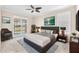 Comfortable main bedroom with a ceiling fan and sliding glass doors that lead to the backyard at 310 Cedar Falls Dr, Apollo Beach, FL 33572