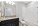 Well-lit bathroom featuring a granite countertop, black vanity, and tiled shower over tub at 3217 Painted Blossom Ct, Lutz, FL 33558