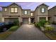 Charming townhouse with blue shutters, well-manicured landscaping, and brick driveway at 3217 Painted Blossom Ct, Lutz, FL 33558