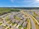 Wide shot of new community featuring manicured lawns, colorful homes, and a picturesque lake at 32714 Brooks Hawk Ln, Wesley Chapel, FL 33543