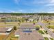 Aerial view features a neighborhood with modern homes, green lawns, and a central lake at 32714 Brooks Hawk Ln, Wesley Chapel, FL 33543