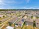 Aerial view displays a neighborhood with diverse home styles, and manicured green spaces at 32714 Brooks Hawk Ln, Wesley Chapel, FL 33543