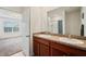 Bathroom with double sink vanity, granite counters, and shower with white tile surround at 32714 Brooks Hawk Ln, Wesley Chapel, FL 33543