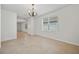 Neutral tile flooring, natural light and a chandelier that highlights the open layout of the room at 32714 Brooks Hawk Ln, Wesley Chapel, FL 33543