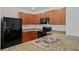 Bright kitchen featuring granite counters, stainless steel sink, and black appliances at 32714 Brooks Hawk Ln, Wesley Chapel, FL 33543