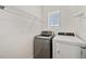 Bright laundry room with appliances and storage shelving at 32714 Brooks Hawk Ln, Wesley Chapel, FL 33543