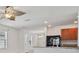 Open living area with kitchen access, lots of natural light, tile flooring at 32714 Brooks Hawk Ln, Wesley Chapel, FL 33543