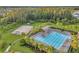 Aerial view of the community pool, tennis courts, and ample seating, surrounded by lush landscaping at 32714 Brooks Hawk Ln, Wesley Chapel, FL 33543