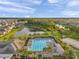 Community pool area featuring palm trees, lounge chairs, and manicured landscaping near a pond at 32714 Brooks Hawk Ln, Wesley Chapel, FL 33543