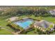 Community pool area featuring palm trees, lounge chairs, a clubhouse, and nearby tennis courts at 32714 Brooks Hawk Ln, Wesley Chapel, FL 33543