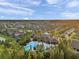 Aerial view of community pool and clubhouse with lush landscaping and neighborhood at 32714 Brooks Hawk Ln, Wesley Chapel, FL 33543