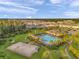 Aerial view of community pool, tennis courts, clubhouse, and surrounding homes in a landscaped neighborhood at 32714 Brooks Hawk Ln, Wesley Chapel, FL 33543