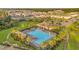 Community pool area featuring palm trees, lounge chairs, a clubhouse, and nearby tennis courts at 32714 Brooks Hawk Ln, Wesley Chapel, FL 33543