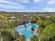 Aerial view of the community pool with cabana, surrounding landscaping, and neighborhood at 32714 Brooks Hawk Ln, Wesley Chapel, FL 33543