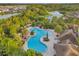 Aerial view of a community pool with landscaping, gazebo, and walking paths near a lake at 32714 Brooks Hawk Ln, Wesley Chapel, FL 33543