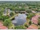 Charming aerial view of homes with a lake and community swimming pool surrounded by mature trees at 3505 Tarpon Woods Blvd # K409, Palm Harbor, FL 34685