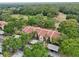 Aerial view of condominium with red tile roof, carports, and mature landscaping at 3505 Tarpon Woods Blvd # K409, Palm Harbor, FL 34685