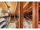 View of attic space with wooden beams, insulation, and available storage on shelves at 3505 Tarpon Woods Blvd # K409, Palm Harbor, FL 34685