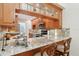 Open kitchen with granite counters, wooden cabinets, stainless steel appliances, and breakfast bar at 3505 Tarpon Woods Blvd # K409, Palm Harbor, FL 34685
