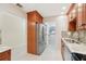 Kitchen boasts wooden cabinets, granite countertops, stainless appliances, and a side-by-side refrigerator at 3505 Tarpon Woods Blvd # K409, Palm Harbor, FL 34685