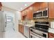 Kitchen featuring wood cabinets, granite countertops, stainless appliances, and laundry access at 3505 Tarpon Woods Blvd # K409, Palm Harbor, FL 34685