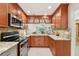 Kitchen featuring wooden cabinets, granite countertops, and stainless steel appliances at 3505 Tarpon Woods Blvd # K409, Palm Harbor, FL 34685